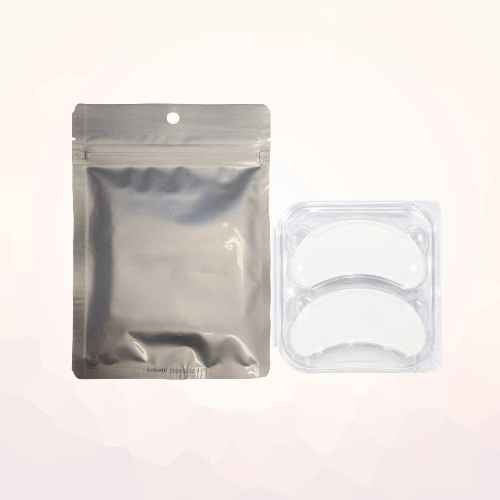 Amber Lash Magic hydrogel eye patches in a clear case beside a silver resealable pouch.