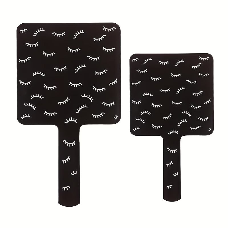 Two black paddle boards with white eyelash pattern on a white background