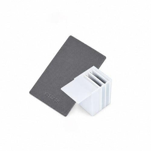 Angled view of a charcoal magnetic lash holder board and white mini storage box on a white background